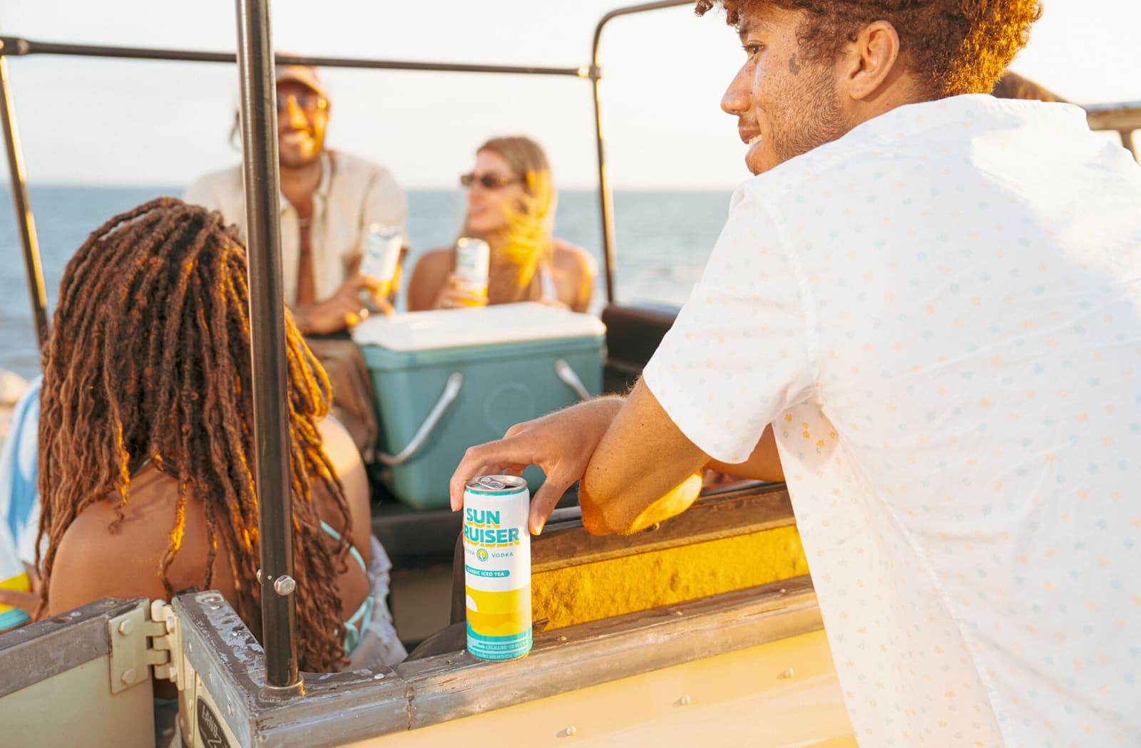A group of people drinking Sun Cruiser at sunset.