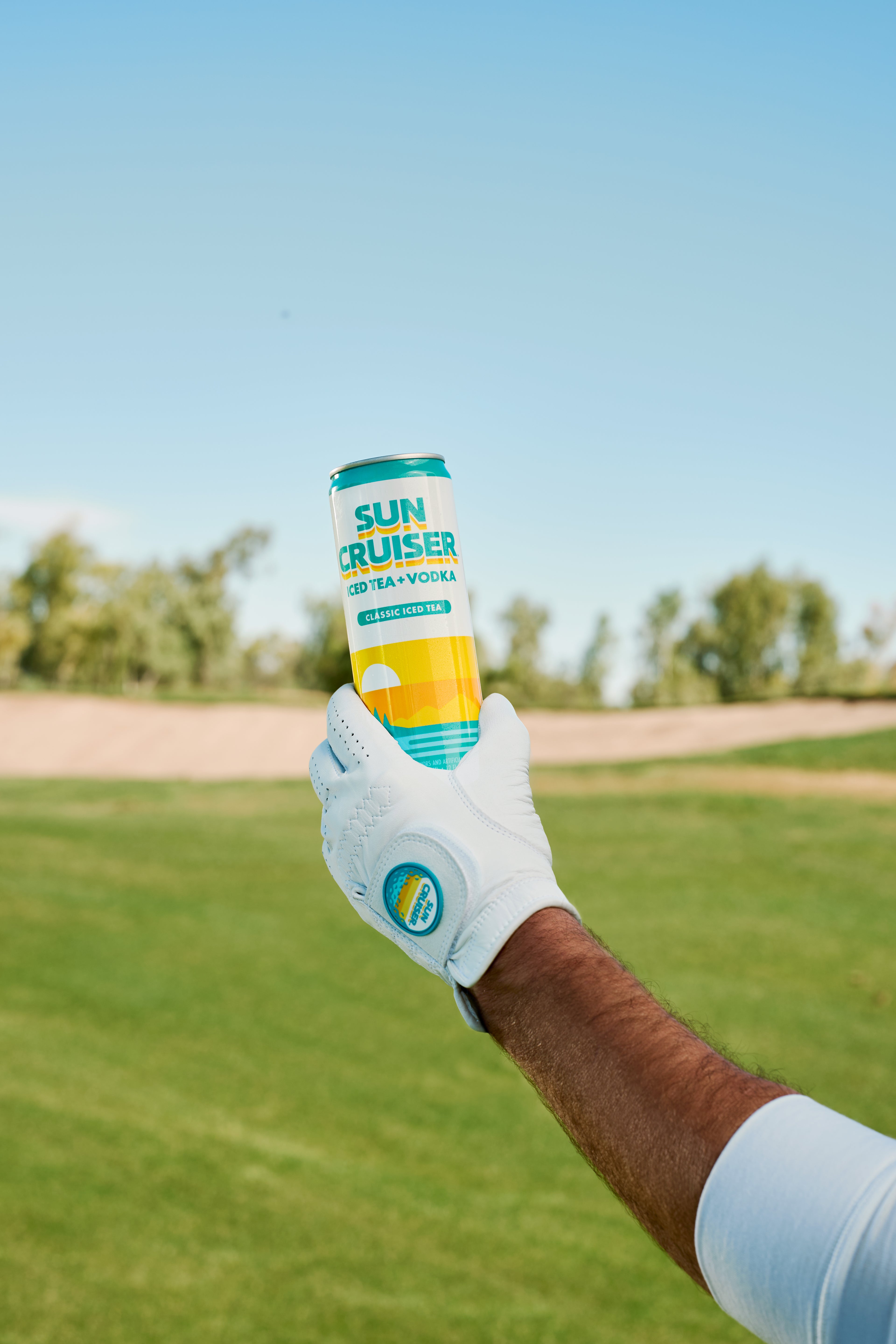 Golfer wearing a white Sun Cruiser X GFore golf glove, holding a Sun Cruiser Classic Iced Tea