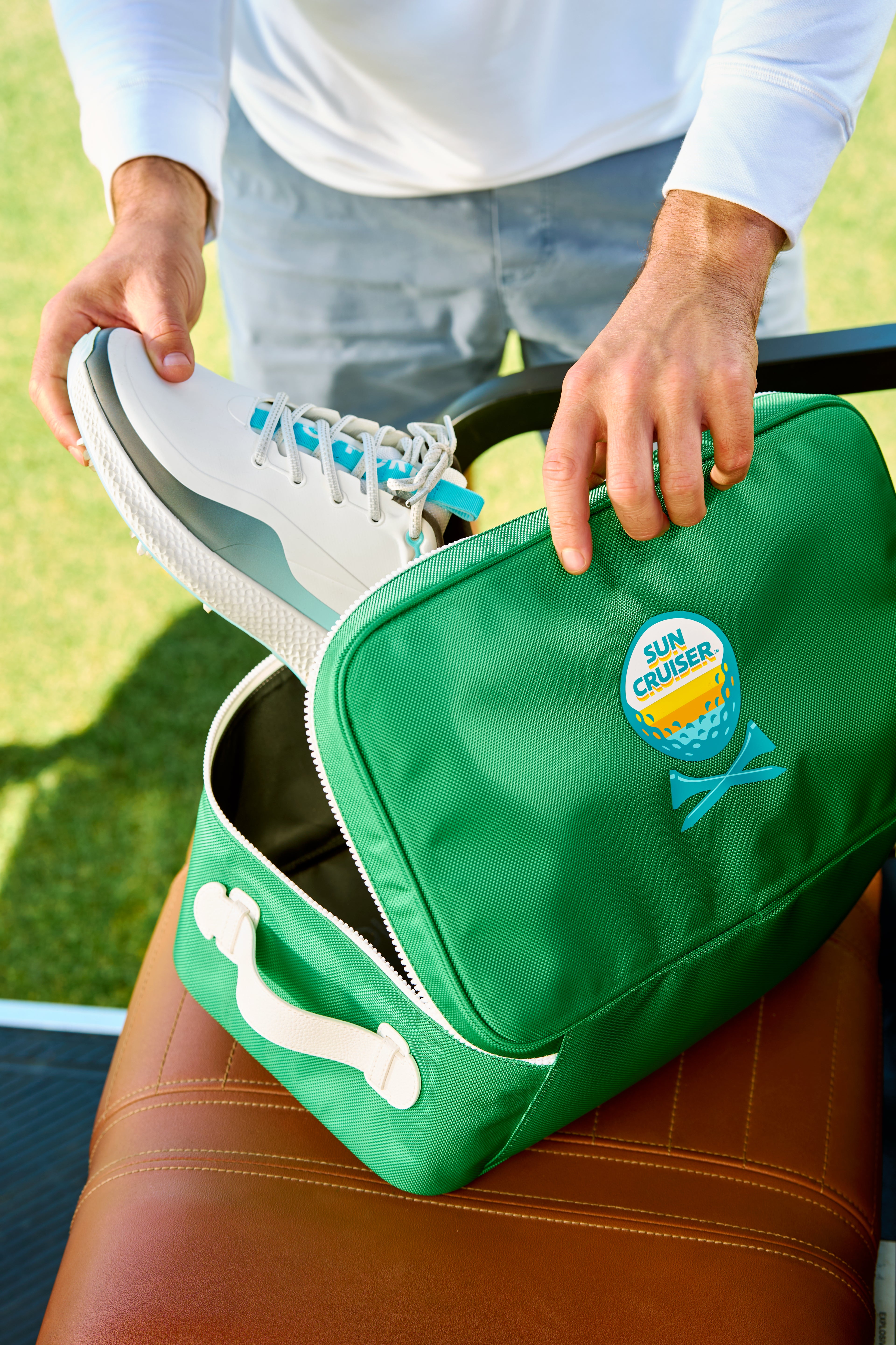 Player putting shoes into Sun cruiser x Gfore golf shoe bag