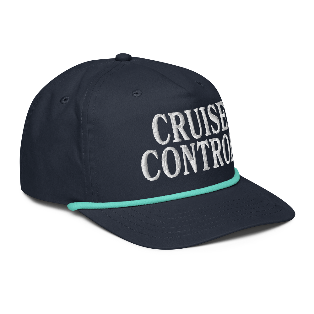 A navy blue baseball cap with 'CRUISE CONTROL' embroidered in white on the front, featuring a thin mint green rope along the edge of the brim.