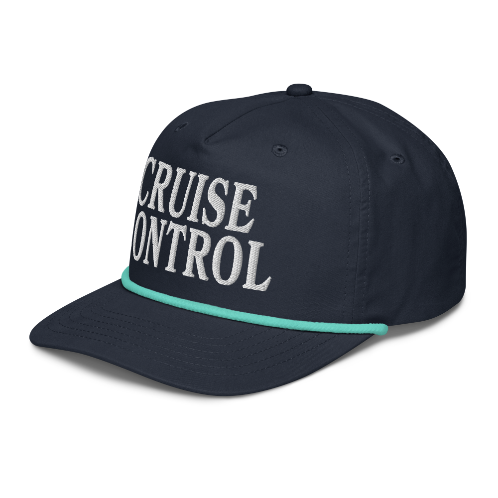 A navy blue baseball cap with 'CRUISE CONTROL' embroidered in white on the front, featuring a thin mint green stripe along the edge of the curved brim.