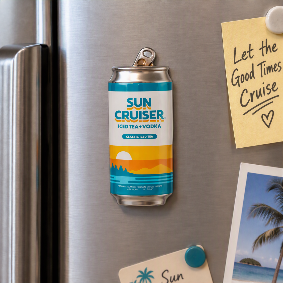 A refrigerator magnet shaped like a Sun Cruiser iced tea can, attached to a stainless steel fridge door next to sticky notes and a beach photo.