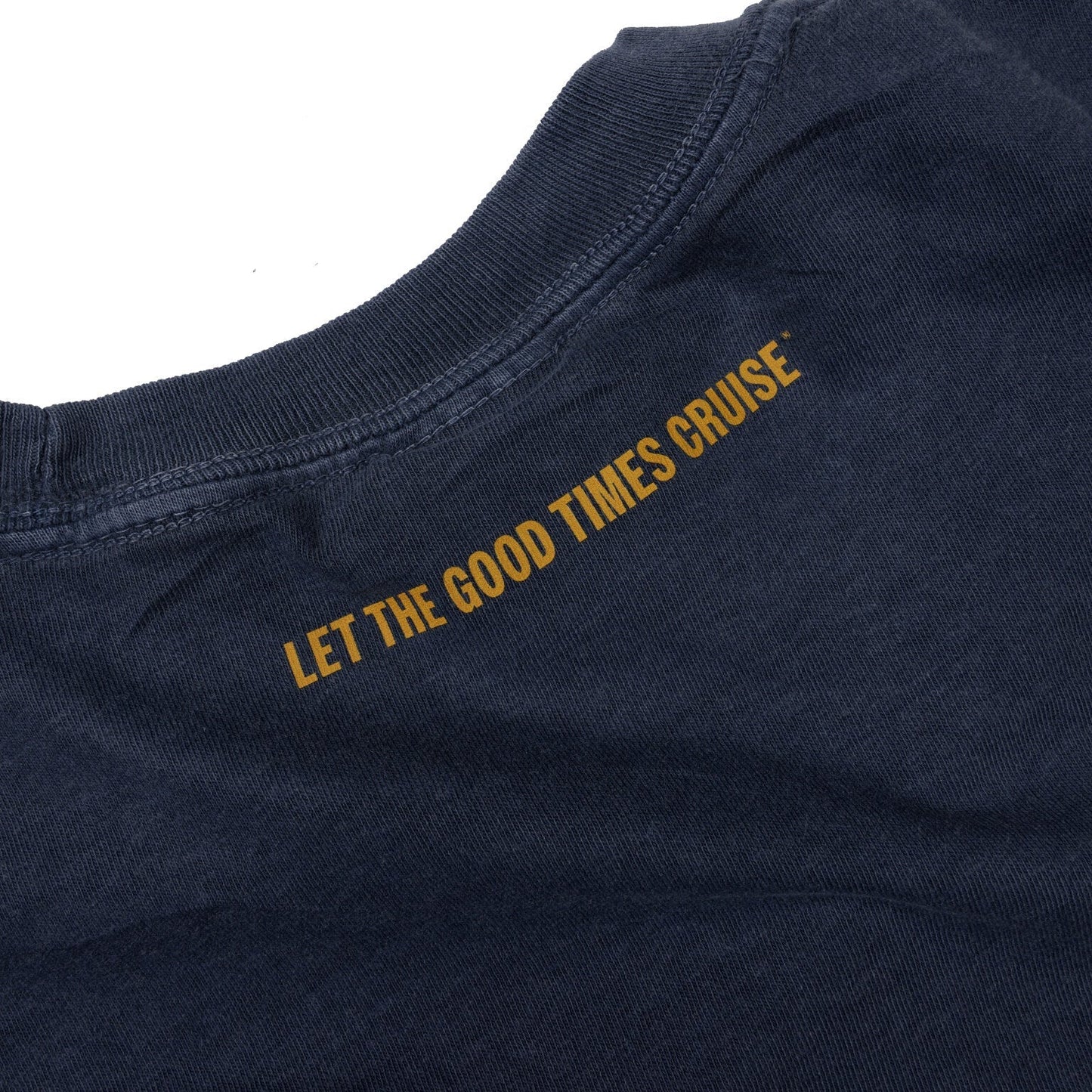 A close-up of the upper back of a faded blue t-shirt. The phrase 'LET THE GOOD TIMES CRUISE' is printed in orange text, running diagonally across the fabric from the left shoulder towards the center.