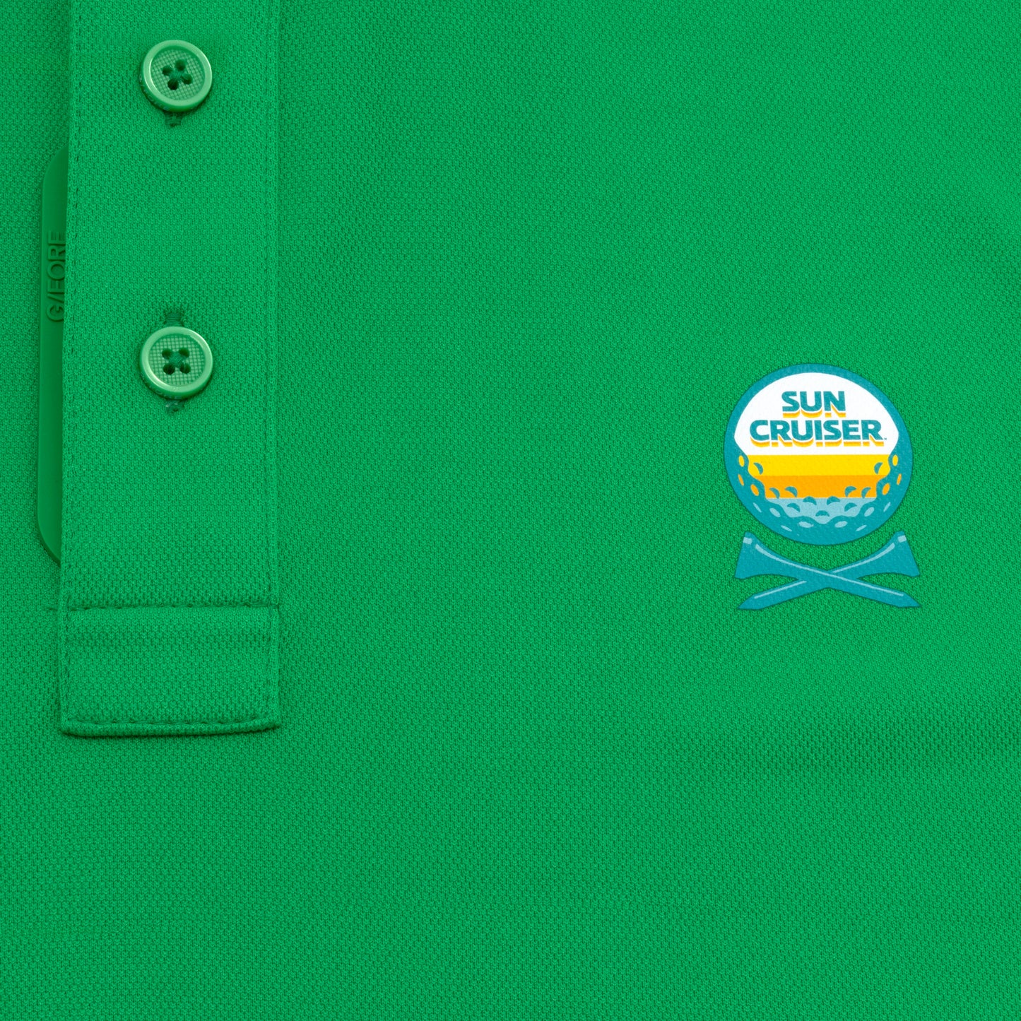 Sun Cruiser x G/FORE green golf polo close-up featuring textured performance fabric, branded button placket, and embroidered chest logo detail