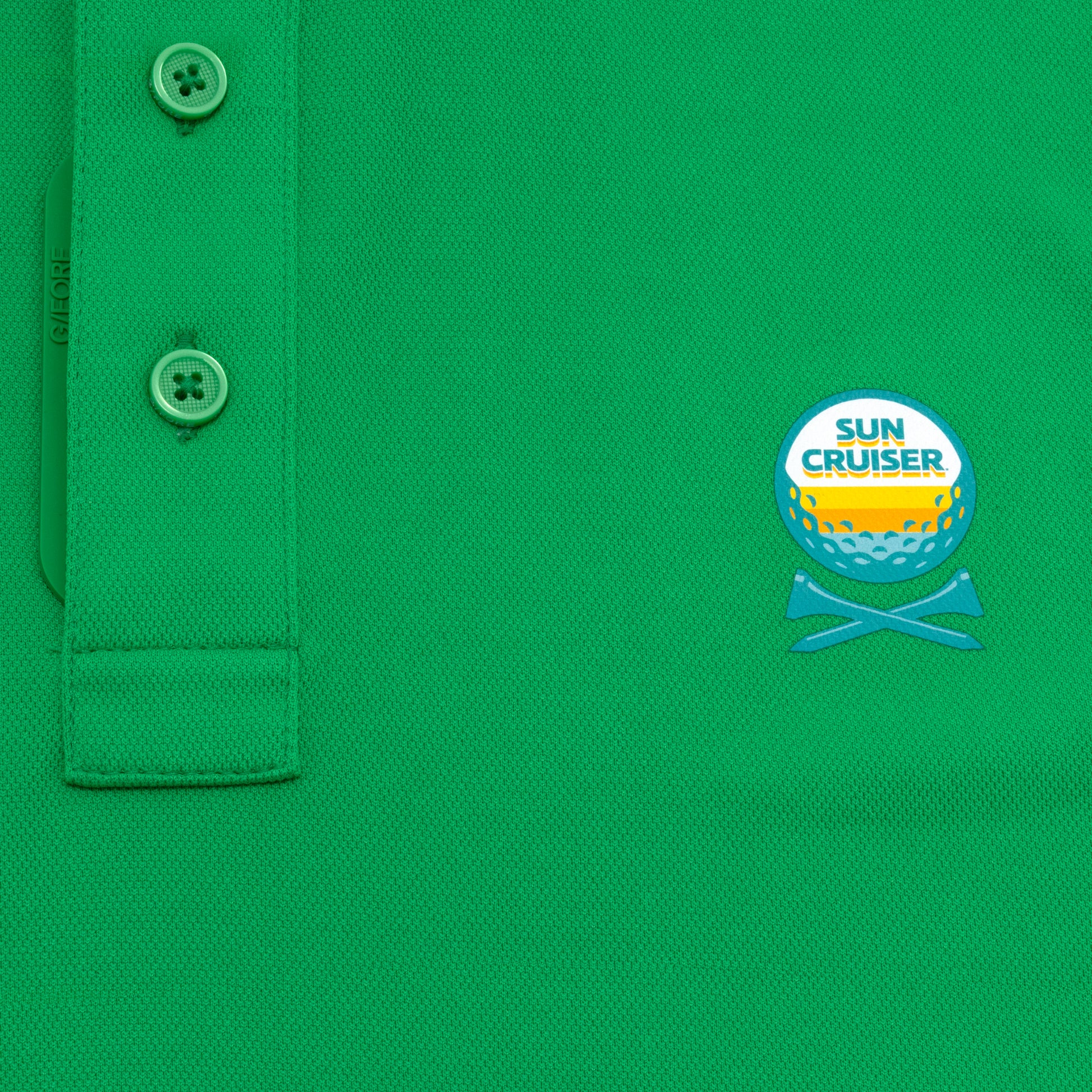 Sun Cruiser x G/FORE green golf polo close-up featuring textured performance fabric, branded button placket, and embroidered chest logo detail