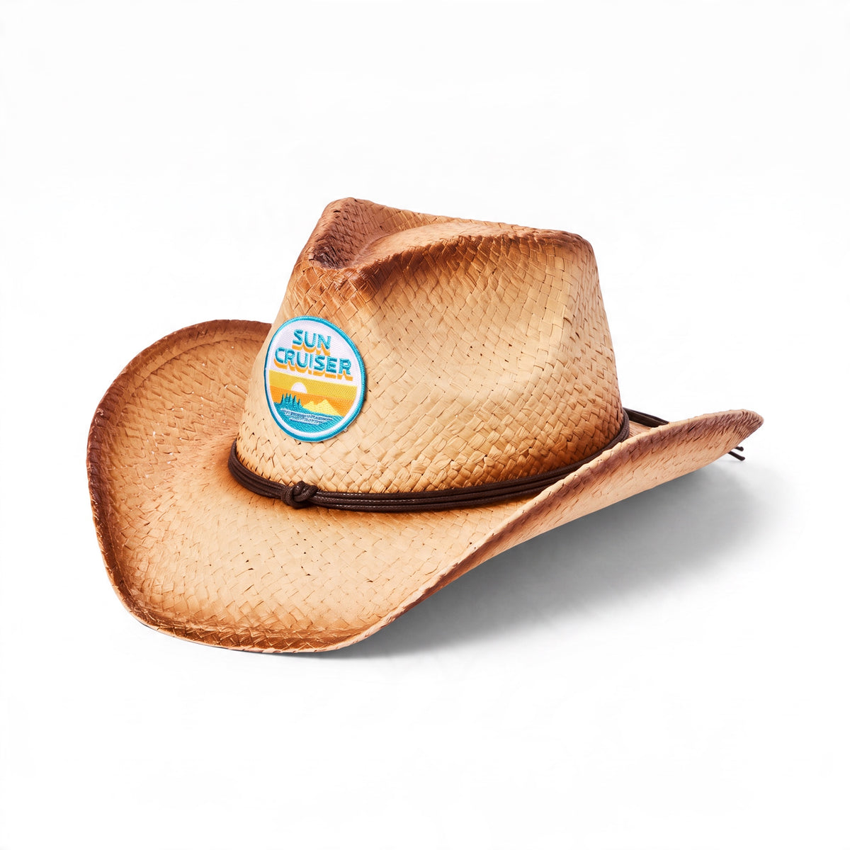 A light brown woven straw cowboy hat with a dark brown cord and a circular 'Sun Cruiser' logo patch on the crown, shown on a white background.