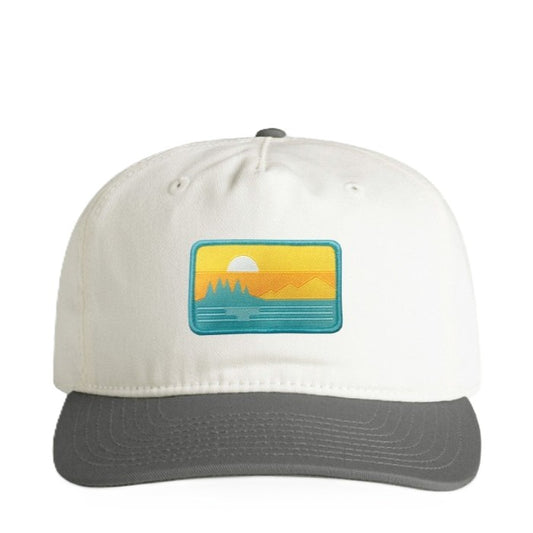 White hat with a dark gray brim and button. It features a rectangle sunset patch bordered in teal, centered on the front. 