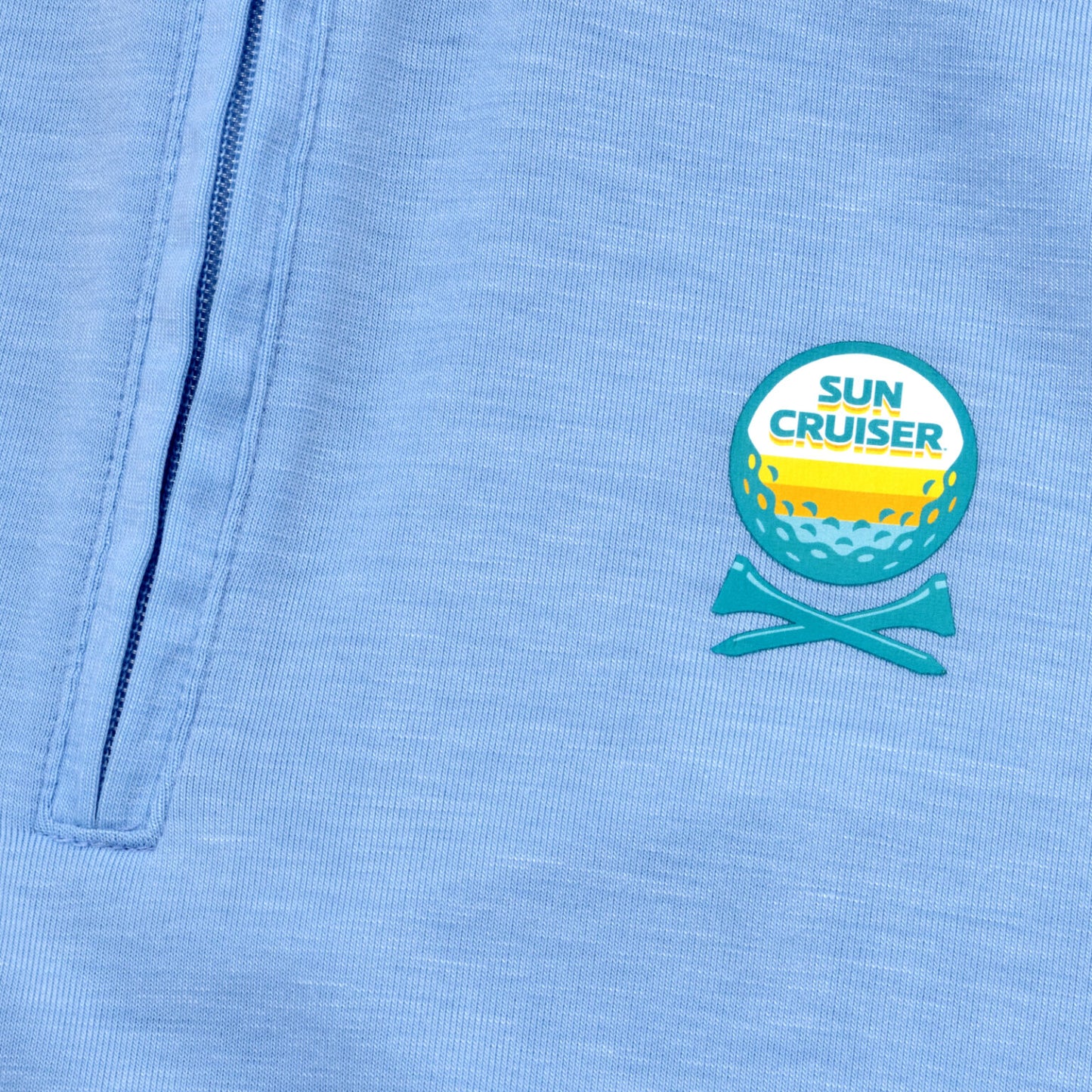 Sun cruiser golf ball and cross tee logo on  a baby blue GFORE quarter zip 
